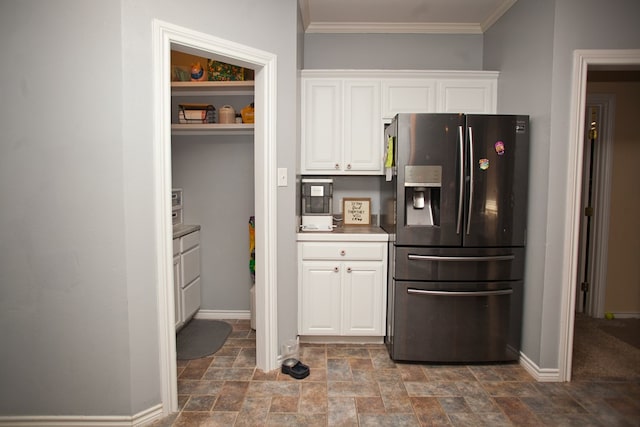 10581 Ballard Rd, San Angelo, TX 76901 - kitchen with stainless steel fridge, stone finish flooring, white cabinets, baseboards, and ornamental molding
