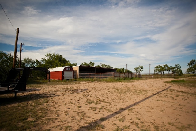 10581 Ballard Rd, San Angelo, TX 76901 - view of yard featuring an outdoor structure, an outbuilding, a garage, and fence