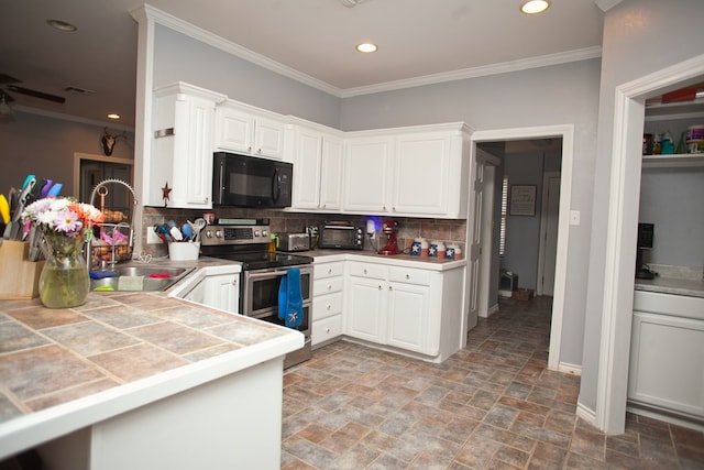 10581 Ballard Rd, San Angelo, TX 76901 - kitchen with black microwave, range with two ovens, a sink, light stone finish floors, and backsplash