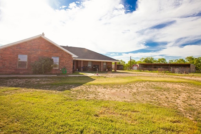 10581 Ballard Rd, San Angelo, TX 76901 - rear view of house featuring brick siding and a lawn