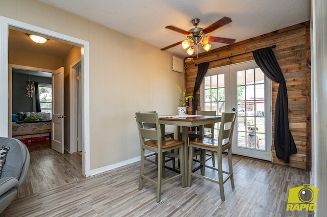 113 N Belaire Ave, San Angelo, TX 76905 - dining area featuring light wood-type flooring, french doors, a ceiling fan, baseboards, and wooden walls