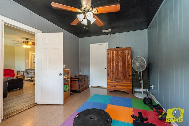 113 N Belaire Ave, San Angelo, TX 76905 - workout area with a ceiling fan, tile patterned floors, and wooden walls