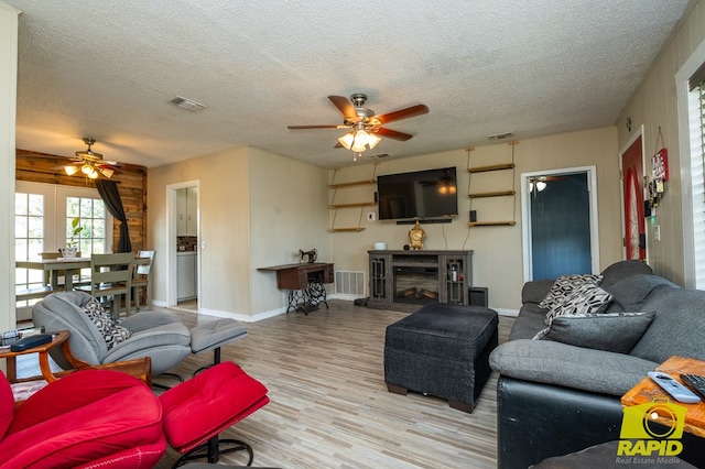 113 N Belaire Ave, San Angelo, TX 76905 - living area with ceiling fan, wood finished floors, a textured ceiling, baseboards, and a fireplace