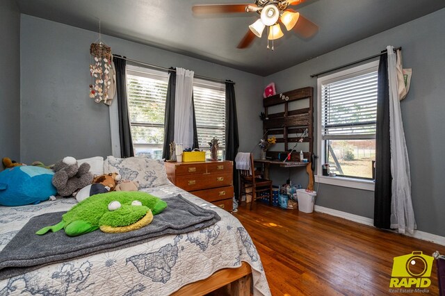 113 N Belaire Ave, San Angelo, TX 76905 - bedroom with wood finished floors, multiple windows, baseboards, and a ceiling fan