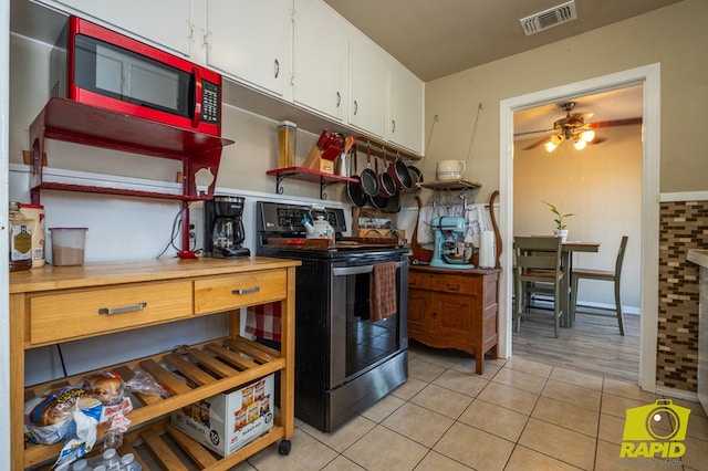 113 N Belaire Ave, San Angelo, TX 76905 - kitchen with stainless steel electric stove, light tile patterned floors, white cabinetry, and ceiling fan
