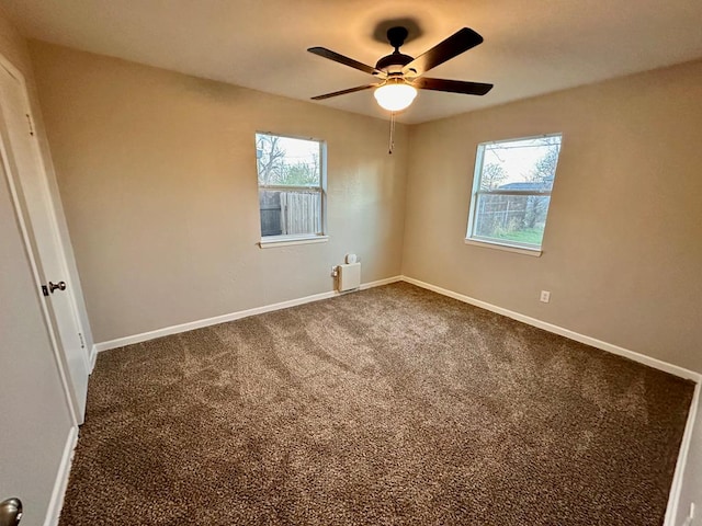 carpeted empty room featuring a wealth of natural light and ceiling fan