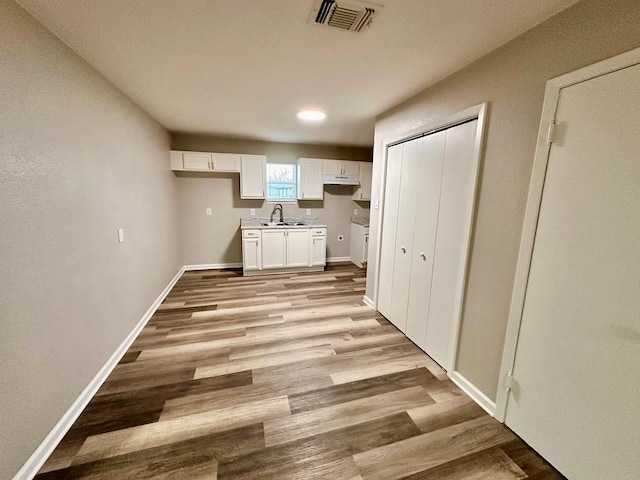 clothes washing area featuring sink and light hardwood / wood-style floors