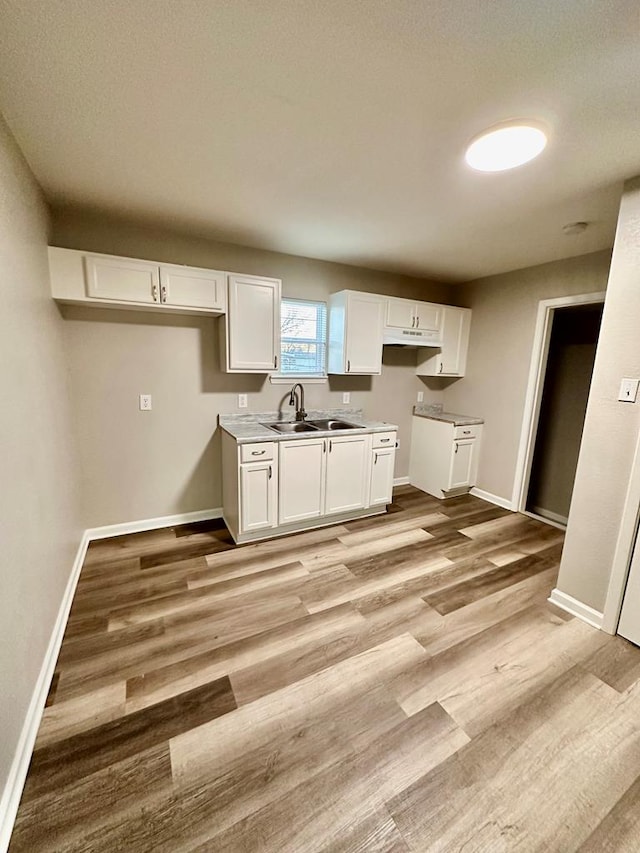 kitchen featuring sink, light hardwood / wood-style flooring, and white cabinets