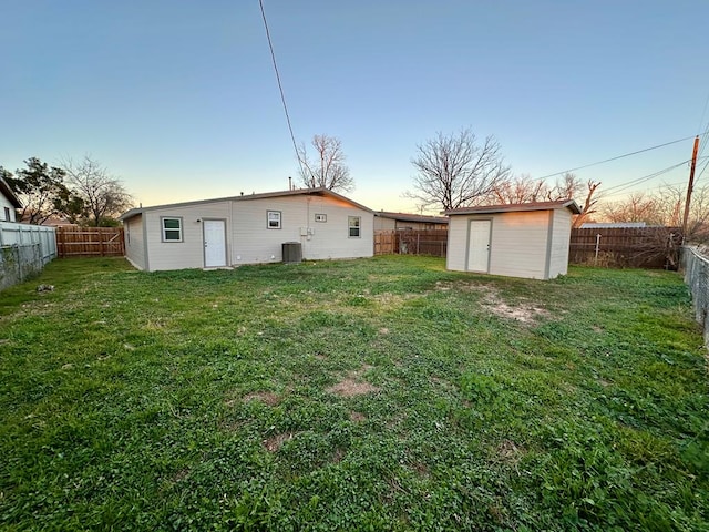 yard at dusk with a shed and central air condition unit