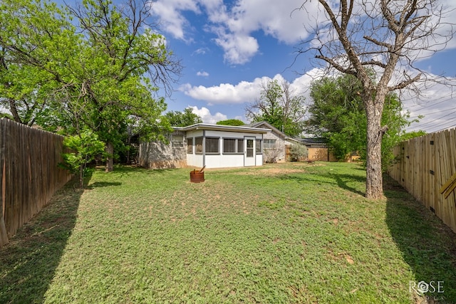view of yard with a sunroom and a fenced backyard