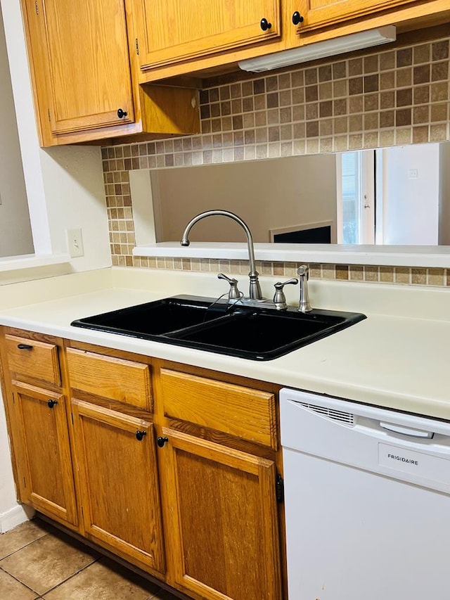 1723 Utah Ave, San Angelo, TX 76904 - kitchen featuring white dishwasher, light countertops, backsplash, a sink, and brown cabinets