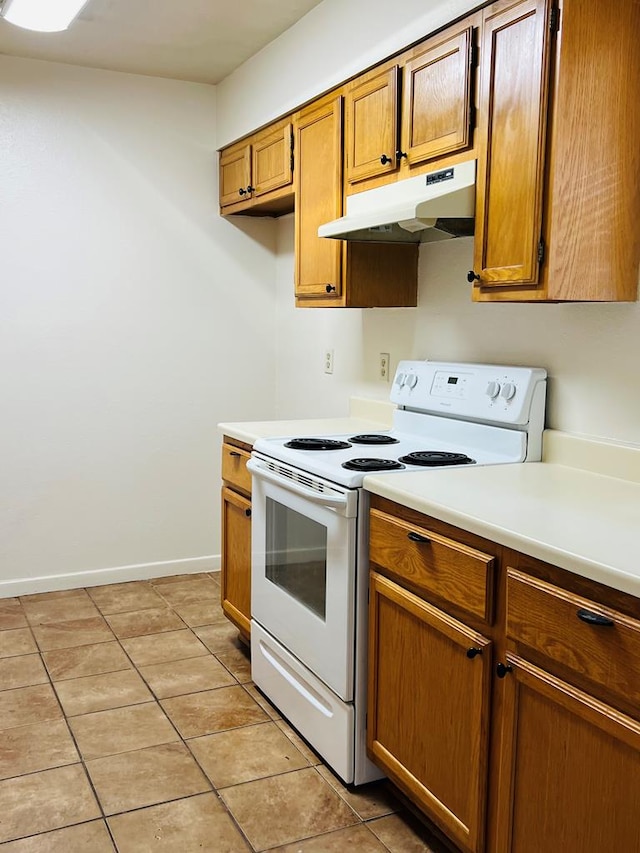 1723 Utah Ave, San Angelo, TX 76904 - kitchen featuring white electric stove, under cabinet range hood, light countertops, light tile patterned floors, and baseboards