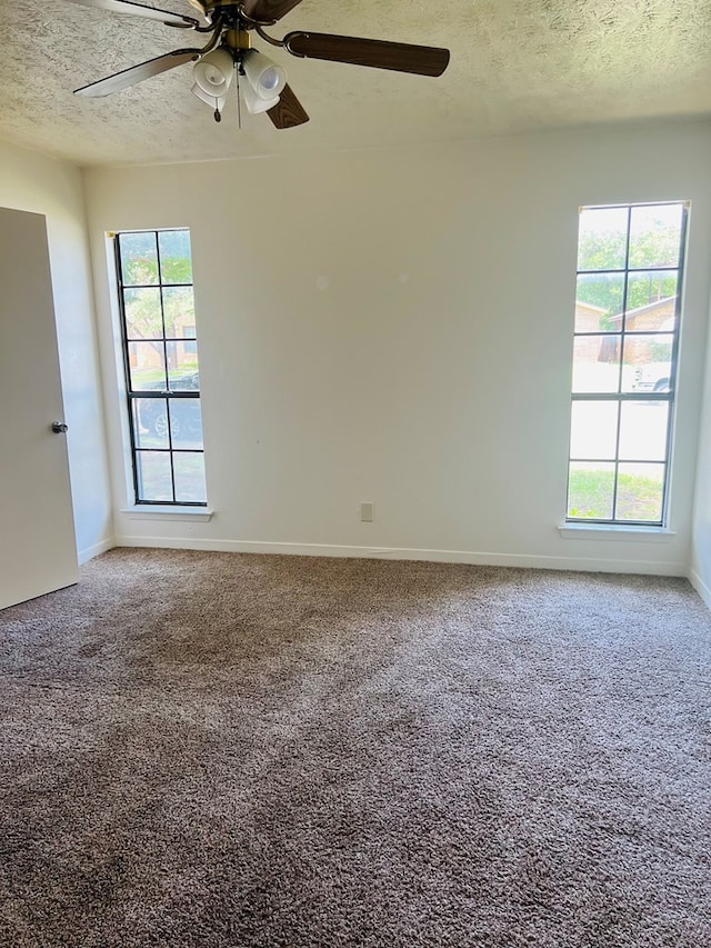 1723 Utah Ave, San Angelo, TX 76904 - empty room featuring a textured ceiling, healthy amount of natural light, ceiling fan, carpet, and baseboards