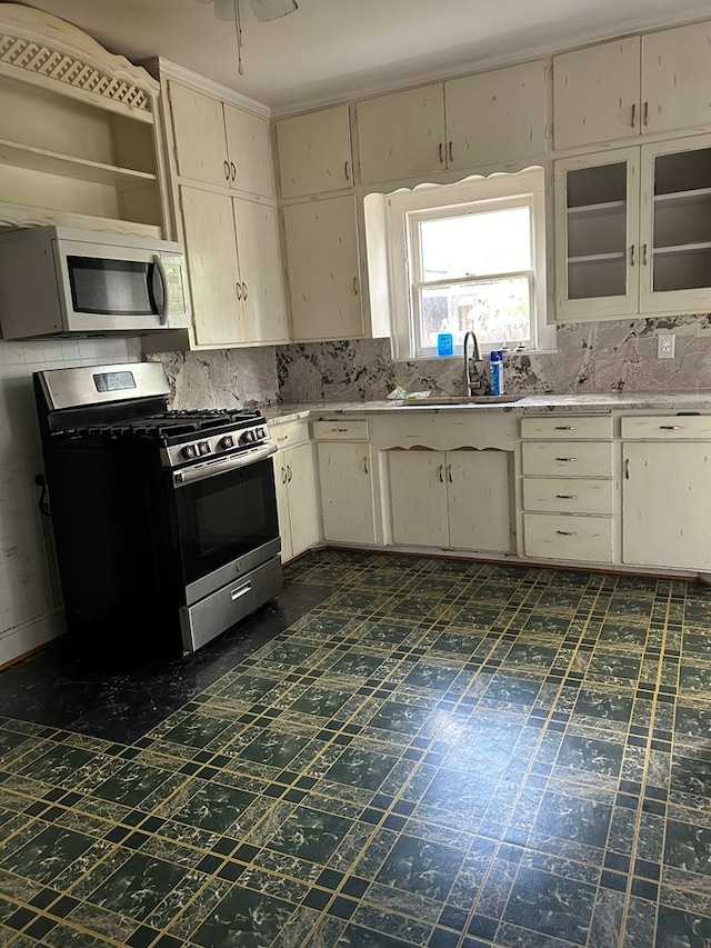 kitchen featuring cream cabinetry, stainless steel appliances, sink, and backsplash