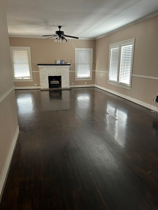 unfurnished living room with a fireplace, plenty of natural light, ornamental molding, and ceiling fan