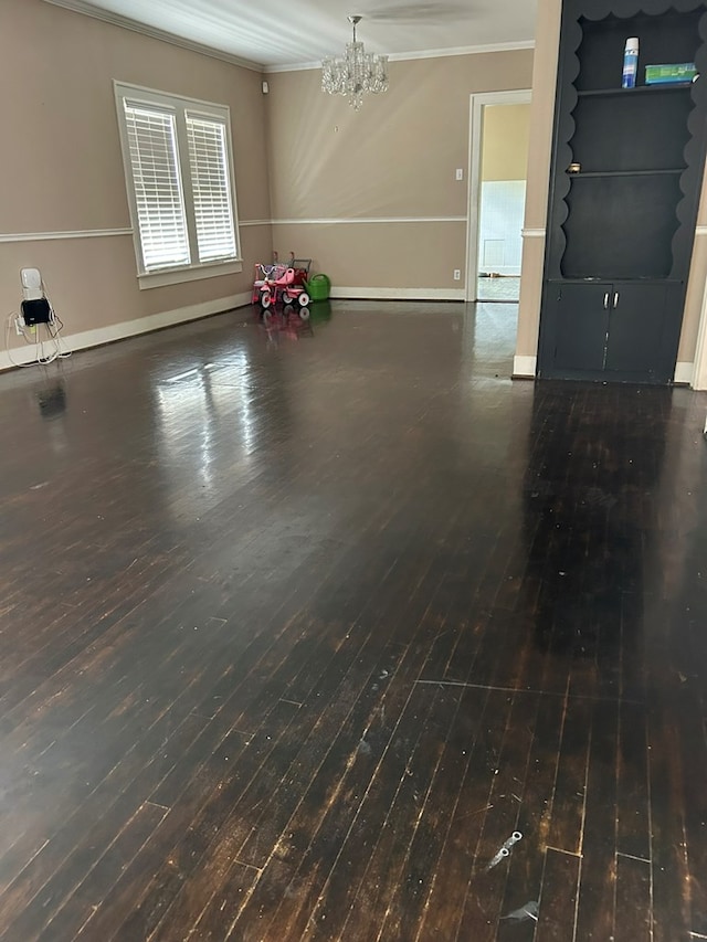 interior space with dark wood-type flooring, ornamental molding, and a notable chandelier