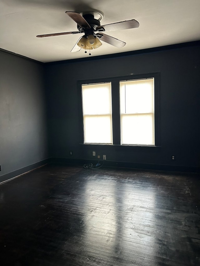 empty room featuring dark wood-type flooring and ceiling fan