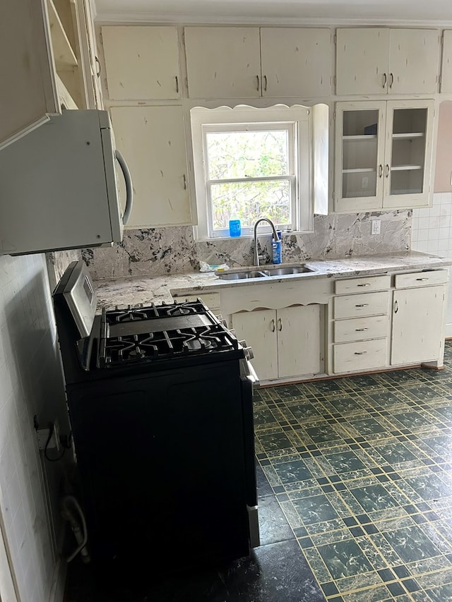 kitchen with sink, decorative backsplash, and range with gas cooktop