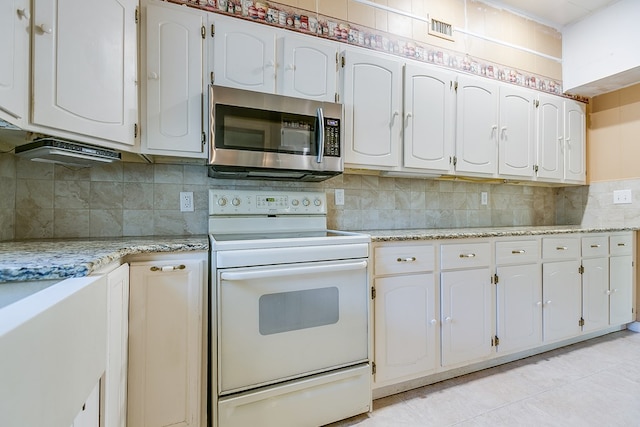 kitchen with visible vents, white cabinetry, decorative backsplash, stainless steel microwave, and white electric range oven