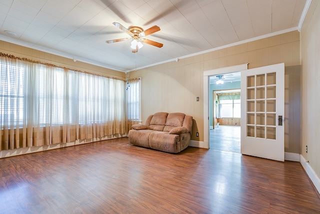 unfurnished room featuring ornamental molding, ceiling fan, baseboards, and wood finished floors