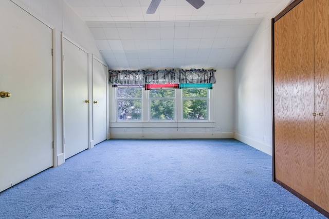 carpeted empty room featuring a ceiling fan and vaulted ceiling