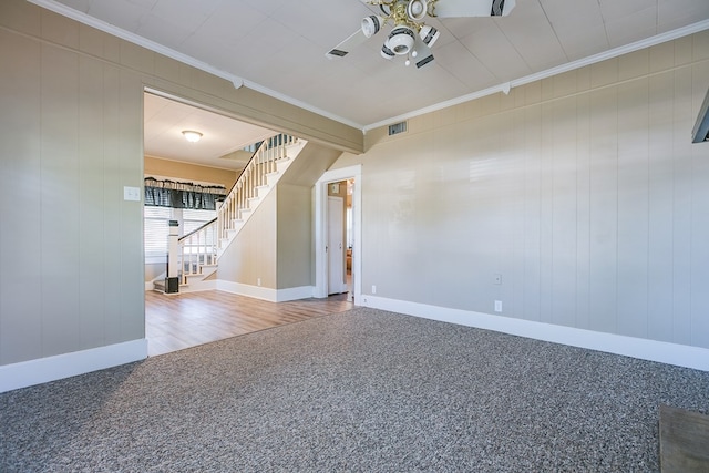 unfurnished room featuring ceiling fan, carpet floors, visible vents, stairs, and crown molding