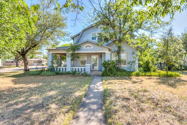 view of front of property featuring a porch, a front lawn, and stucco siding