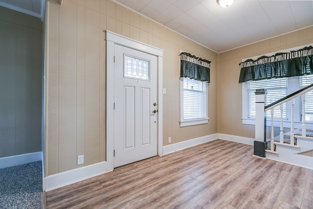 entryway featuring stairs, baseboards, wood finished floors, and crown molding