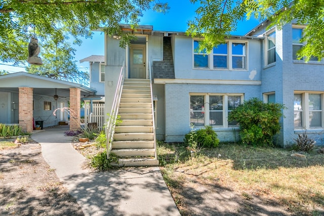 view of front of property with stairs and brick siding