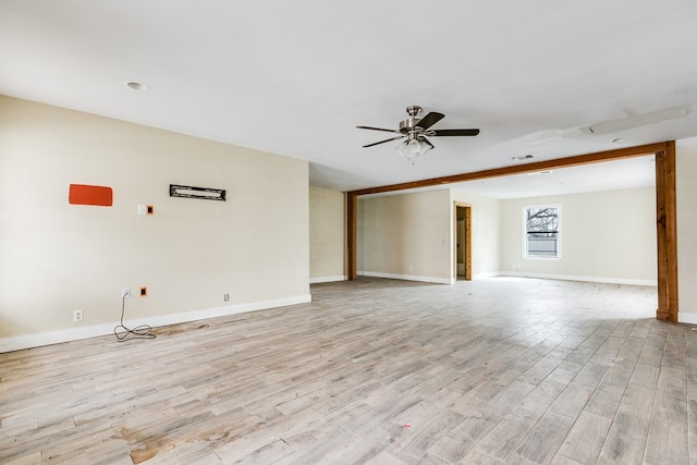 unfurnished room with light wood finished floors, baseboards, and a ceiling fan