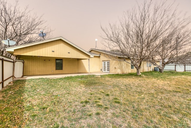 back of property featuring a patio area, a lawn, french doors, and fence