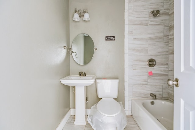 bathroom featuring tub / shower combination, toilet, and baseboards