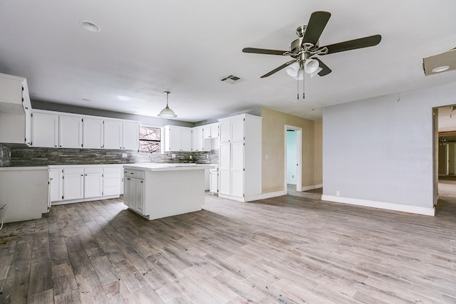 kitchen with tasteful backsplash, visible vents, light wood-type flooring, and open floor plan