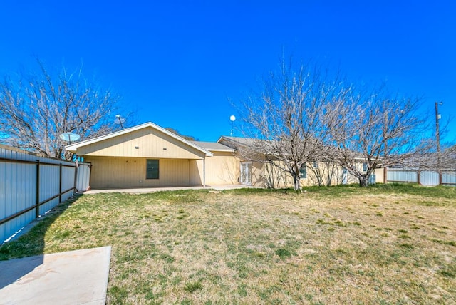 back of property featuring a yard and fence