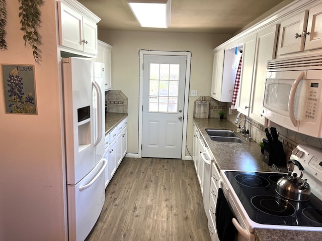 kitchen with sink, light hardwood / wood-style flooring, white appliances, decorative backsplash, and white cabinets