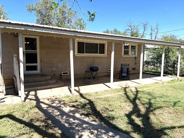 rear view of property with a patio and a lawn