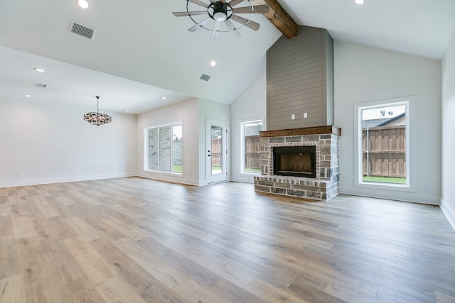 unfurnished living room with beamed ceiling, a healthy amount of sunlight, high vaulted ceiling, and light hardwood / wood-style flooring