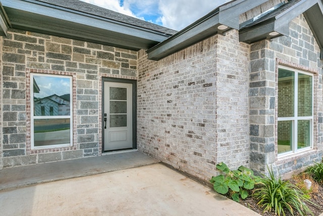 view of exterior entry with a patio area