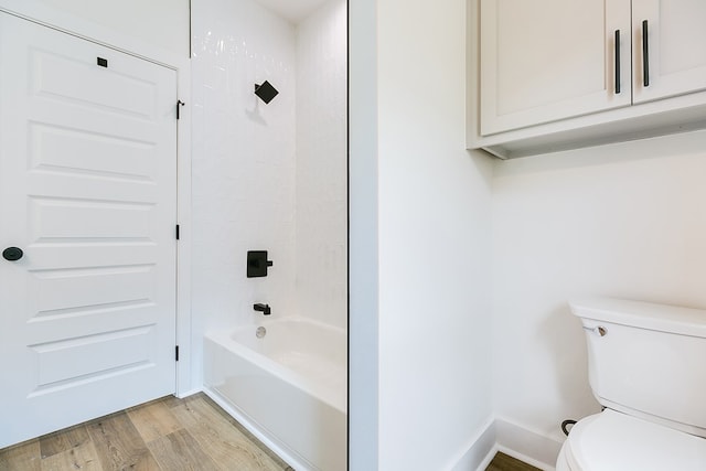 bathroom with bathing tub / shower combination, hardwood / wood-style floors, and toilet