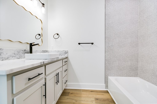 bathroom featuring vanity, a bathtub, and hardwood / wood-style flooring