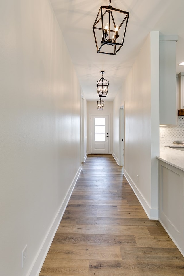 entryway with hardwood / wood-style floors and an inviting chandelier