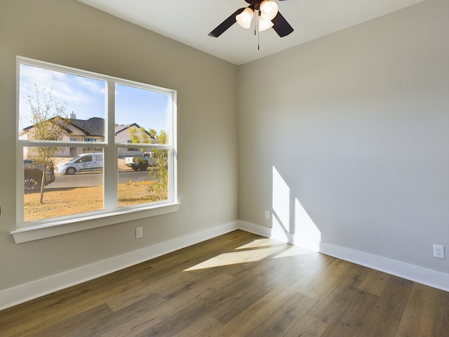 empty room featuring dark wood-type flooring, ceiling fan, and plenty of natural light