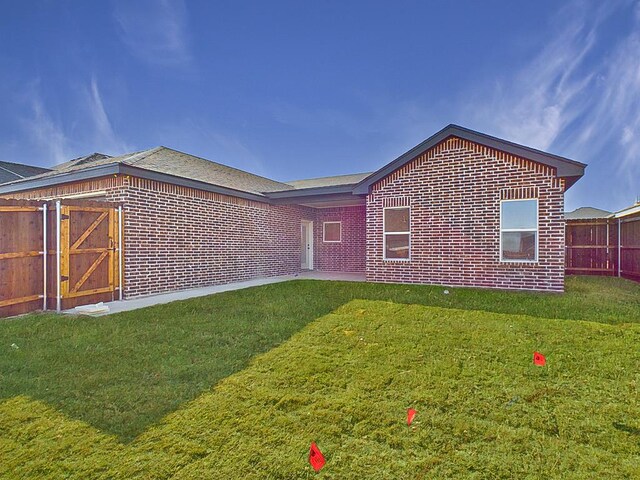 rear view of property with a yard