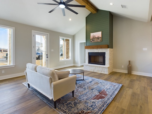 living room featuring wood-type flooring, vaulted ceiling with beams, ceiling fan, and a fireplace