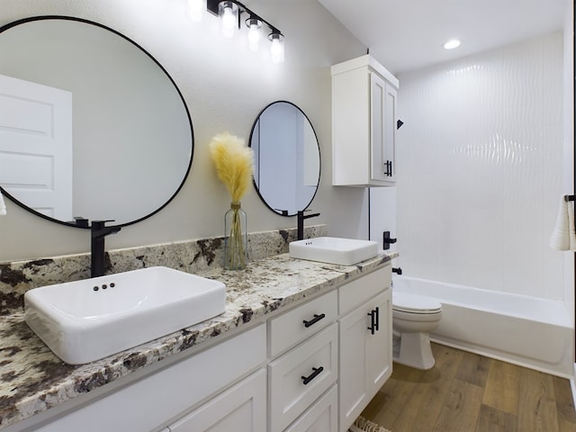 full bathroom featuring vanity, wood-type flooring,  shower combination, and toilet