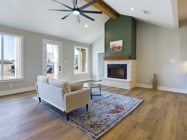 living room with vaulted ceiling with beams, hardwood / wood-style flooring, plenty of natural light, and a fireplace