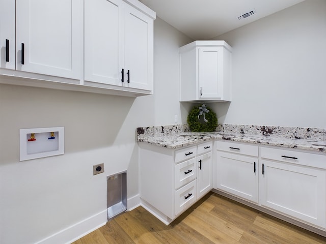 clothes washing area featuring cabinets, hookup for an electric dryer, hookup for a washing machine, and light hardwood / wood-style floors