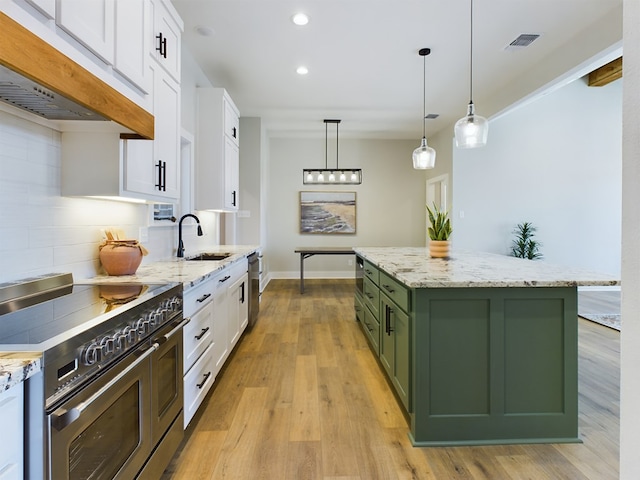 kitchen featuring white cabinetry, stainless steel appliances, green cabinetry, a kitchen island, and decorative backsplash