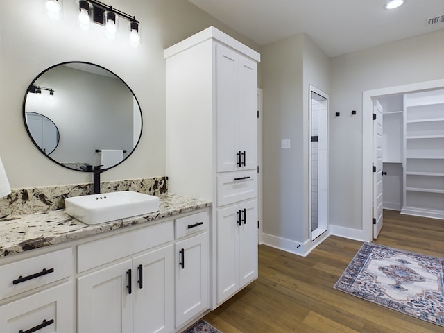 bathroom with vanity, hardwood / wood-style floors, and walk in shower