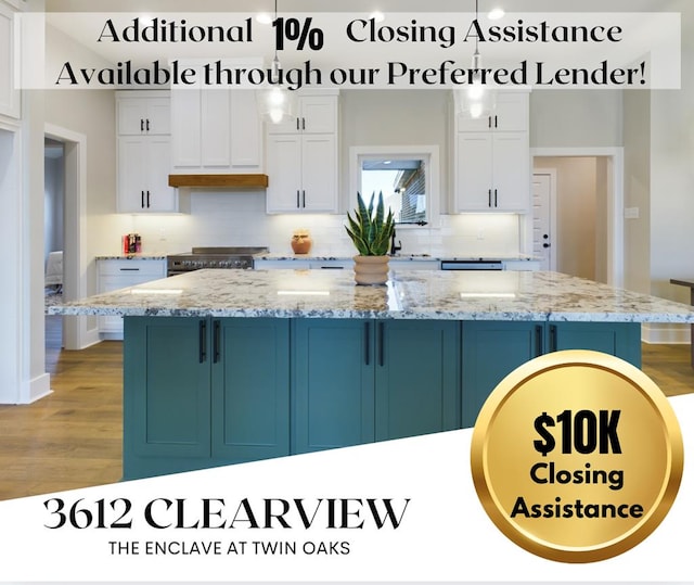 kitchen featuring white cabinetry, pendant lighting, backsplash, and light stone counters